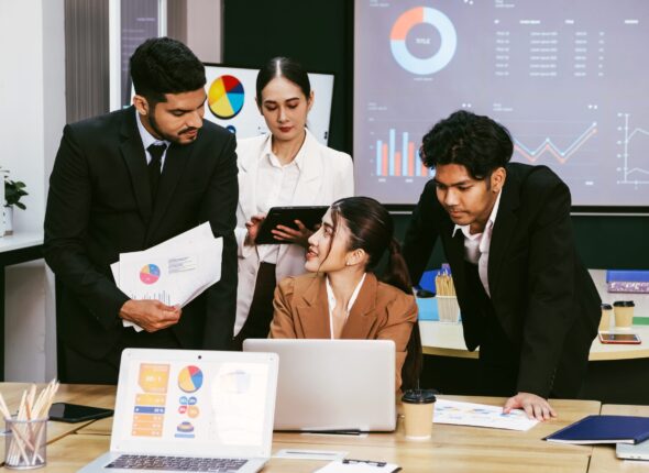 cheerful-confident-asian-businesswoman-stands-back-her-office-colleagues-scaled.jpg
